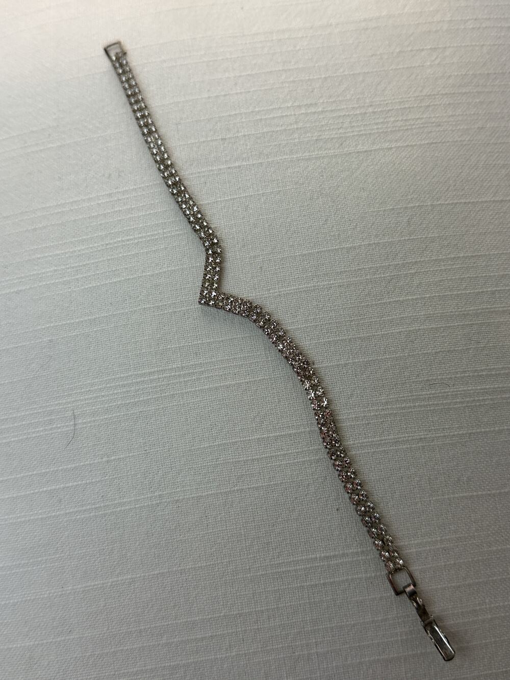 Silver tone double row rhinestone tennis bracelet with fold over clasp